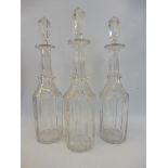 A set of three Georgian glass decanters and matching stoppers, both engraved with grapes and leaves.