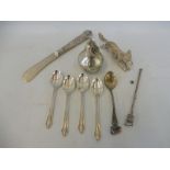 A silver pear shaped container, a silver butter knife, four silver spoons, a twizzle stick etc.