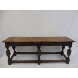 An 18th Century style carved oak long stool, with half fluted bulbous supports.