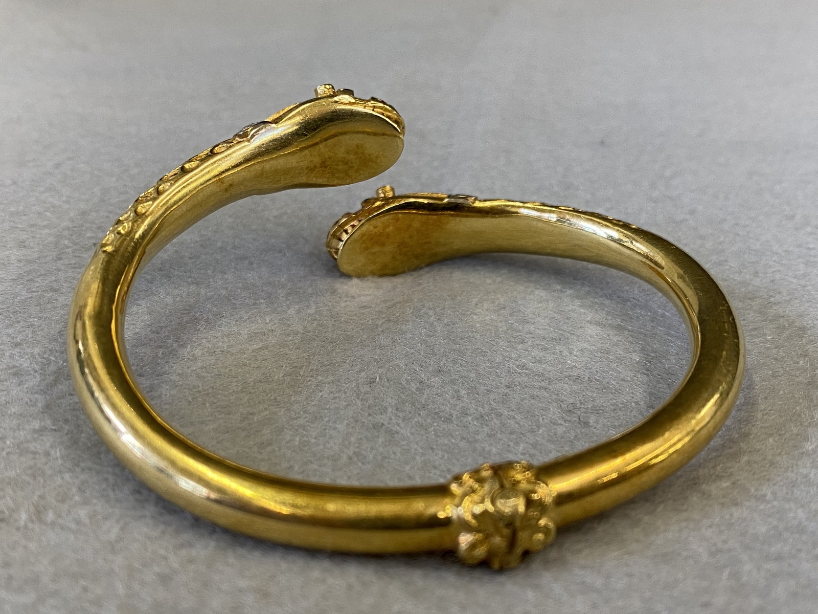 An 18k gold double headed serpent bangle, both heads encrusted with diamonds and semi-precious - Image 2 of 3