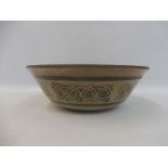 A studio pottery bowl with repeating intertwined design to the outside, impressed mark to base, 10