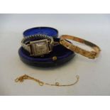 A 9ct gold bangle in a leather and velvet lined case, a 9ct gold lady's wristwatch and a chain.