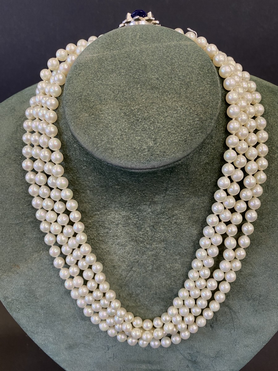 An impressive four string pearl choker with central blue stone surrounded by paste.