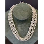 An impressive four string pearl choker with central blue stone surrounded by paste.