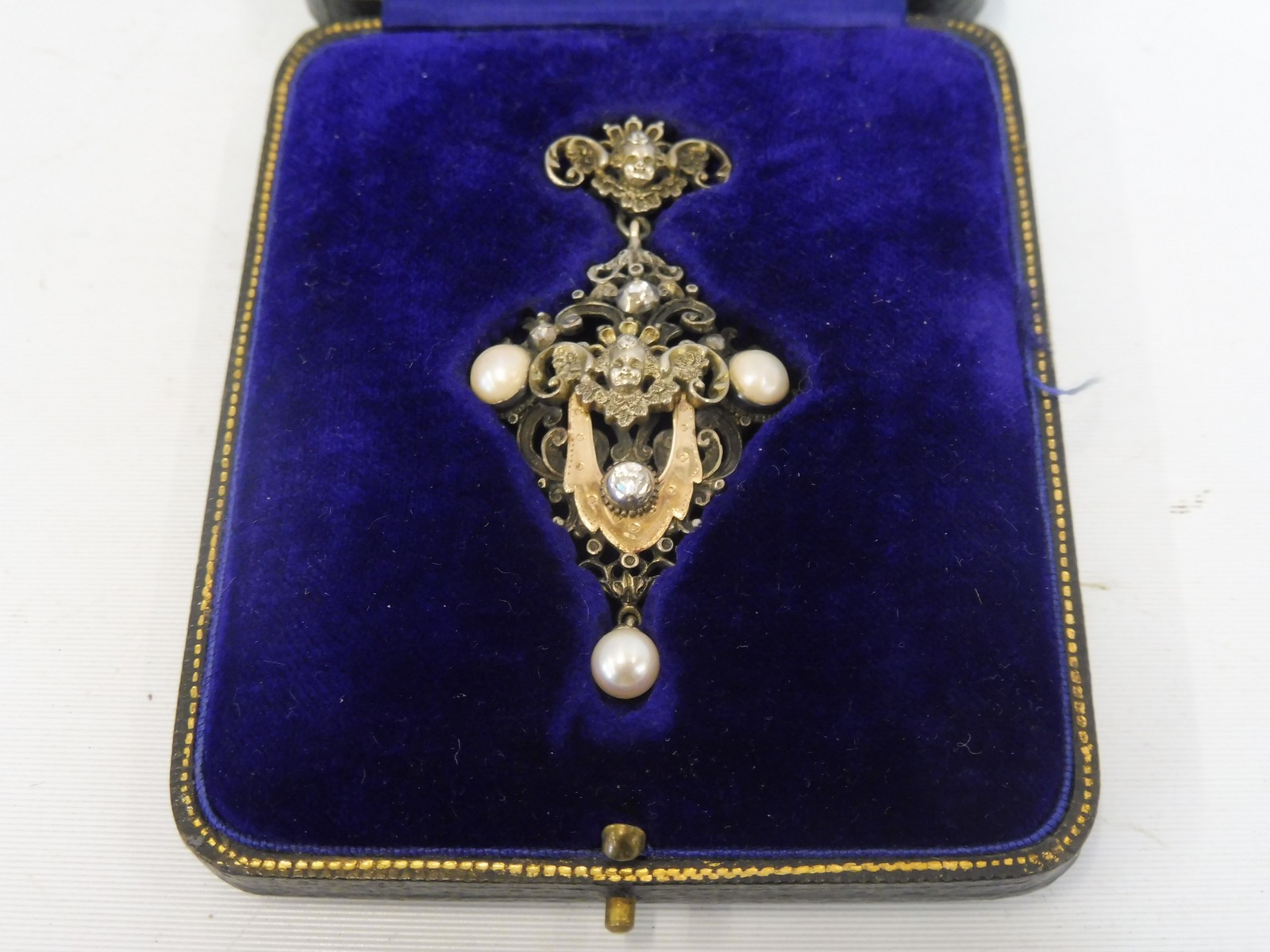 An unusual white metal and gold mounted pendant with central diamond, three further diamonds, two