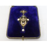 An unusual white metal and gold mounted pendant with central diamond, three further diamonds, two