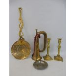 A brass skimmer, a pair of brass candlesticks and a brass bugle.
