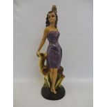 A tall 1950s/1960s plaster figure in the form of a lady forming a lamp.