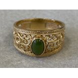 A 9ct gold filigree work ring set with an oval central green stone (possibly jade). Approximately
