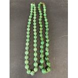 Two green hard stone bead necklaces.