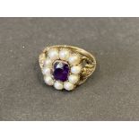 An early Victorian gold ring (unmarked) set with a central amethyst surrounded by seed pearls, the