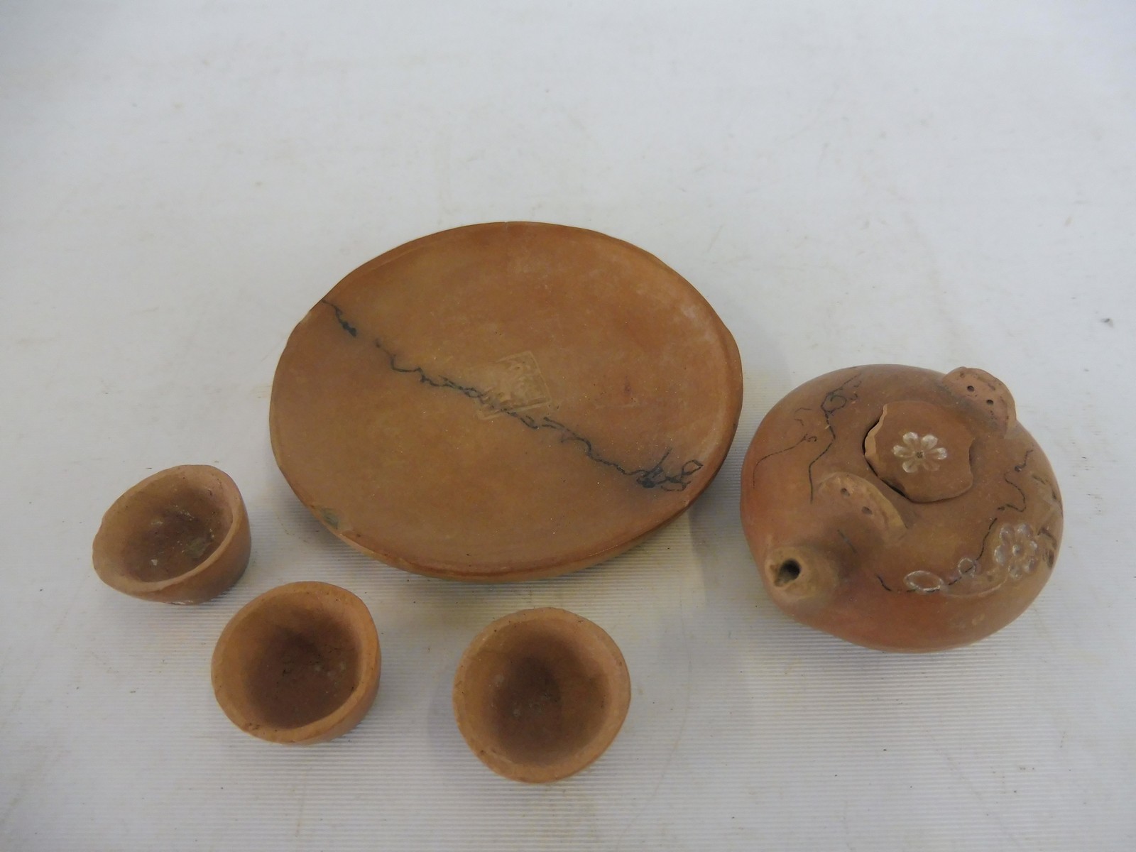 A miniature Chinese terracotta tea set, signature to saucer.