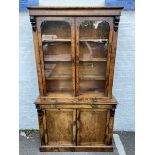 A Victorian walnut and boxwood strung bookcase cabinet of two glazed doors above cupboard doors.