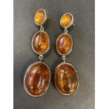 An unusual pair of silver mounted earrings, each of three graduated amber stones, marked C&B.