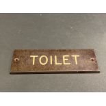 A small bakelite door plaque for 'Toilet', 4 x 1 1/4".