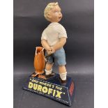 A rare Durofix shop advertising figure in the form of a young boy with a catapult having just broken