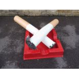 A large scale novelty advertising carnival pair of oversized cigarettes and ashtray.