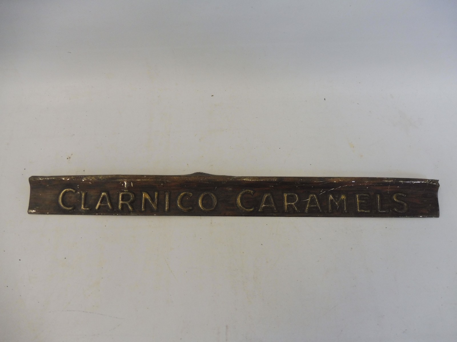 A Clarinco Caramels embossed tin advertising shelf strip.