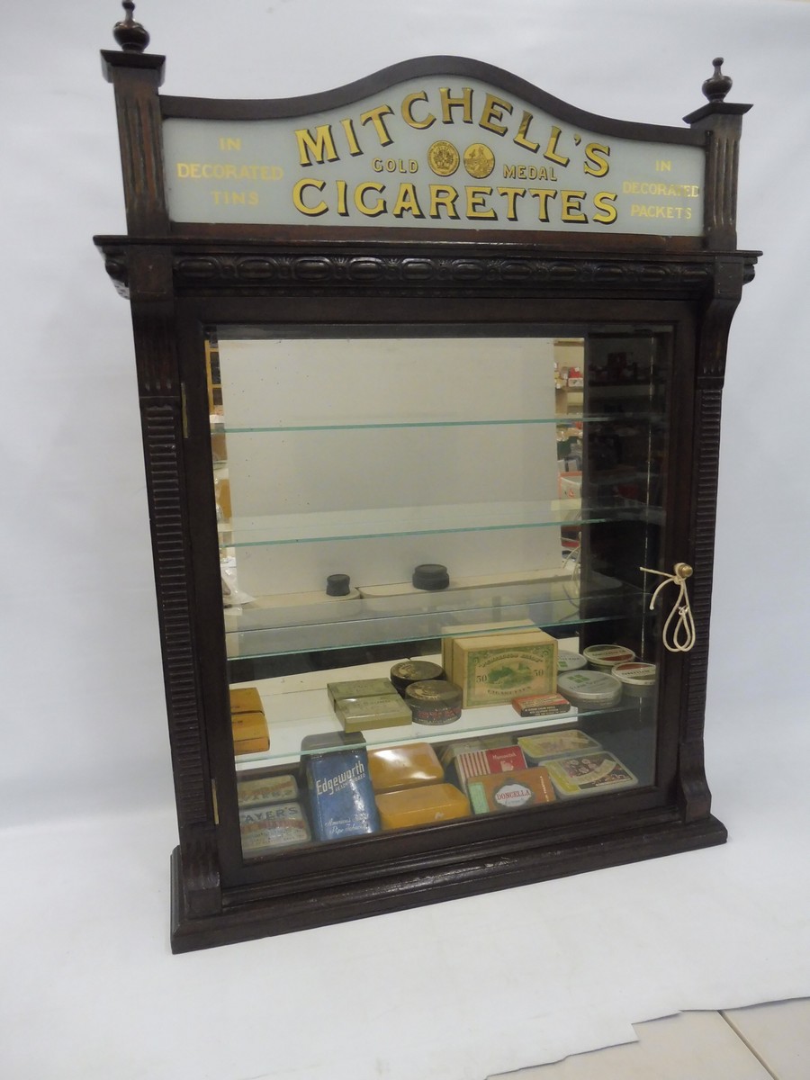 A counter top front opening dispensing cabinet with glass advertising pediment for Mitchell's