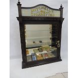 A counter top front opening dispensing cabinet with glass advertising pediment for Mitchell's