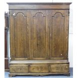 A 17thC style oak triple front Wardrobe, by Bryn Hall Furniture, with dentil cornice above three