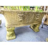 A reconstituted stone rectangular Garden Trough, embossed in high relief on both sides with lions