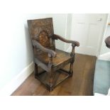 An antique carved oak Wainscot Chair, the arched panelled back with floral marquetry decoration,