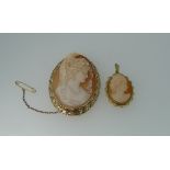 Two oval shell cameo Brooches, one with ropetwist and loop border in 9ct yellow gold, the other with