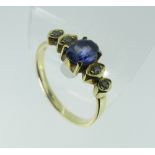 A sapphire and diamond Ring, the central facetted oval sapphire with two graduated diamonds on