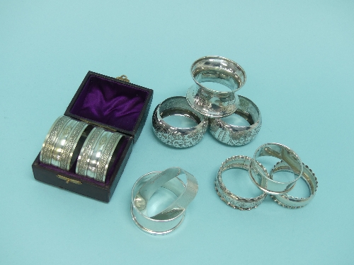 A collection of eight silver various Napkin Rings, together with a cased pair of silver plated