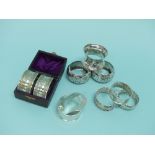 A collection of eight silver various Napkin Rings, together with a cased pair of silver plated
