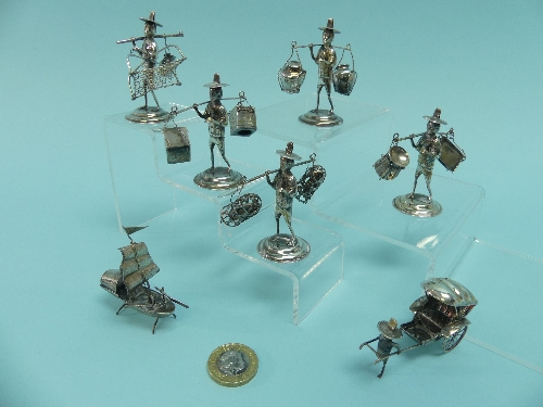 A collection of seven small Oriental silver Models, five of street Vendors carrying various