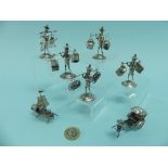 A collection of seven small Oriental silver Models, five of street Vendors carrying various