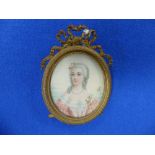 A French portrait miniature of a lady, entitled "Petit", oval, in ornate gilt-metal easel frame,