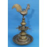 An 18th/19th century bronze Deccan oil lamp, surmounted with a cockerel, the seven-light tray on a