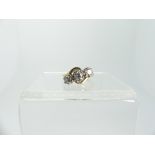 An 18ct gold three stone diamond Ring, mounted on the cross, each diamond individually claw set, the