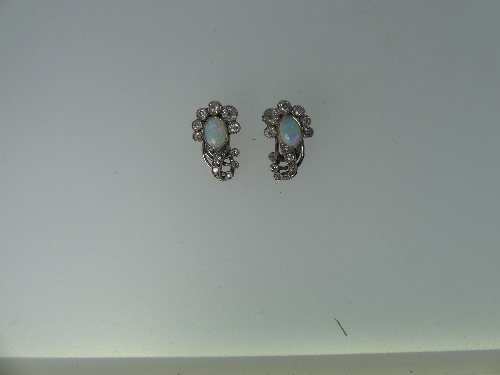 A pair of opal and diamond Ear Clips, the oval opal mounted above six millegrain set graduated