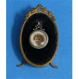 An over-painted photograph portrait miniature, of a child, in gold circular pendant frame inset with