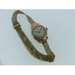 A 9ct gold ladies Wristwatch, with circular dial and black Arabic numerals, on a 9ct gold fine-