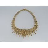 An 18ct yellow gold Necklace, formed of a graduating mesh with applied flowerhead design front and