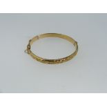 A 9ct yellow gold hollow hinged Bangle, the front with foliate engraved decoration, approx weight