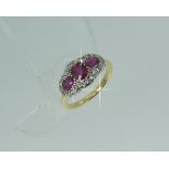 An attractive ruby and diamond three stone Ring, the central oval ruby vertically set, the two