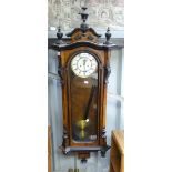 An Edwardian walnut Vienna Regulator Wall Clock, with dark wood decorations and finials, 17in (43cm)