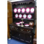 A late 19thC/early 20thC oak Dresser, with a detachable plank back Plate Rack, comprising three open
