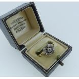 A diamond cluster Ring, the central stone of 1/8th carat surrounded by nine smaller stones, the