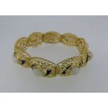 An 18ct yellow gold and opal Bracelet, formed of nine oval shaped pierced gold links, each with a