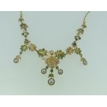 An unmarked yellow gold, emerald and seed pearl Necklace, formed of flowerheads and drops, with