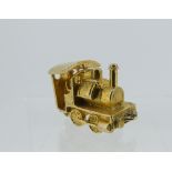 A 9ct yellow gold charm, in the form of a steam engine, the hinged cab opening to reveal driver, 4.