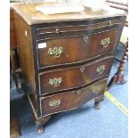 A reproduction mahogany serpentine-front small Chest of Drawers, with brushing slide, raised on