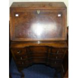 An Edwardian burr walnut and banded Bureau, the hinged lid enclosing a fitted compartment above